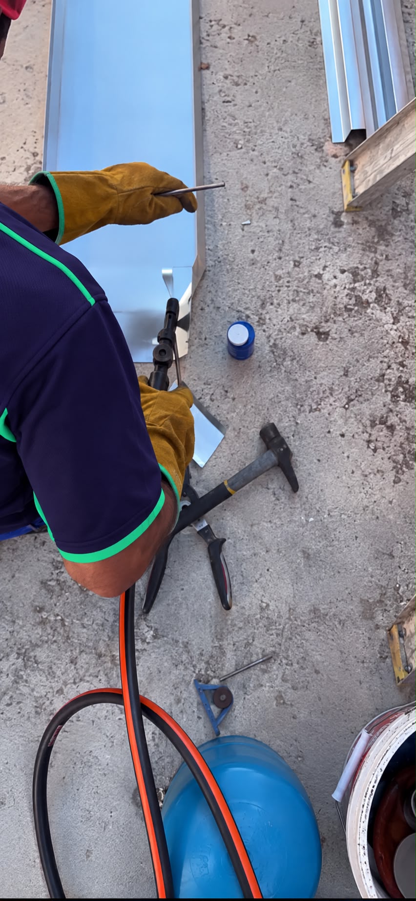 Profissional a preparar uma peça de zinco em obra
